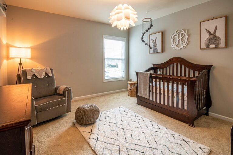 Baby nursery with a wooden crib and rocking chair, a room that benefits from a nursery air purifier