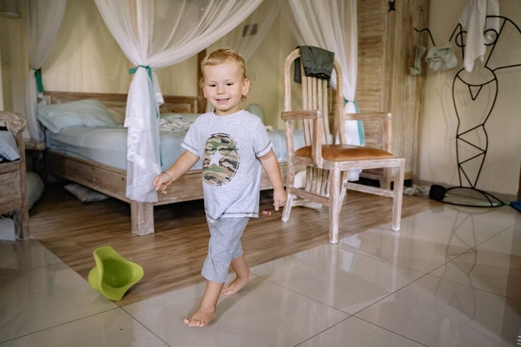 Happy toddler walking barefoot across a bright bedroom floor